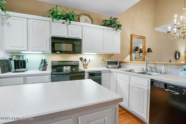 kitchen featuring black appliances, a sink, light countertops, and white cabinetry