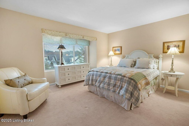 bedroom with baseboards and light colored carpet