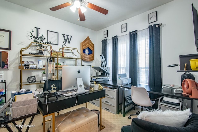 carpeted home office featuring ceiling fan
