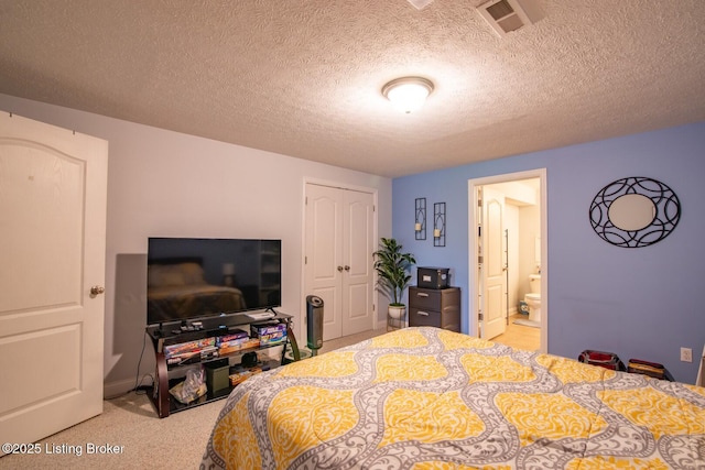bedroom with a closet, a textured ceiling, connected bathroom, and carpet floors