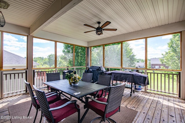 sunroom / solarium with ceiling fan, outdoor dining space, plenty of natural light, and beamed ceiling