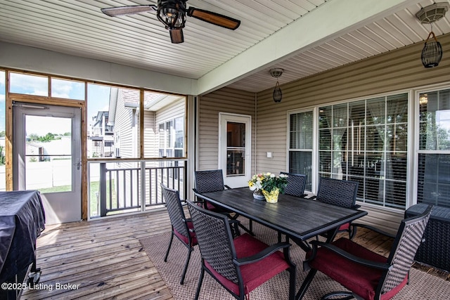 sunroom / solarium with a ceiling fan and outdoor dining space