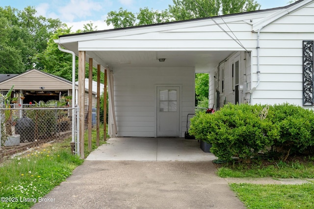 view of parking featuring fence and a carport