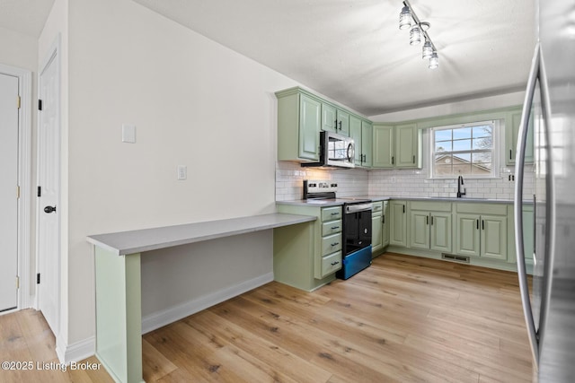 510 University Dr, Radcliff, KY 40160 - kitchen featuring green cabinetry, stainless steel appliances, a sink, light wood-style flooring, and decorative backsplash