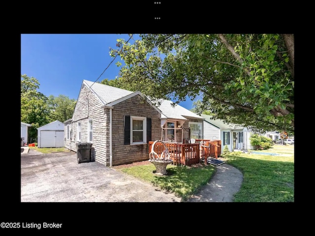 4328 S 1st St, Louisville, KY 40214 - bungalow with an outdoor structure, a deck, a garage, a front yard, and stone siding