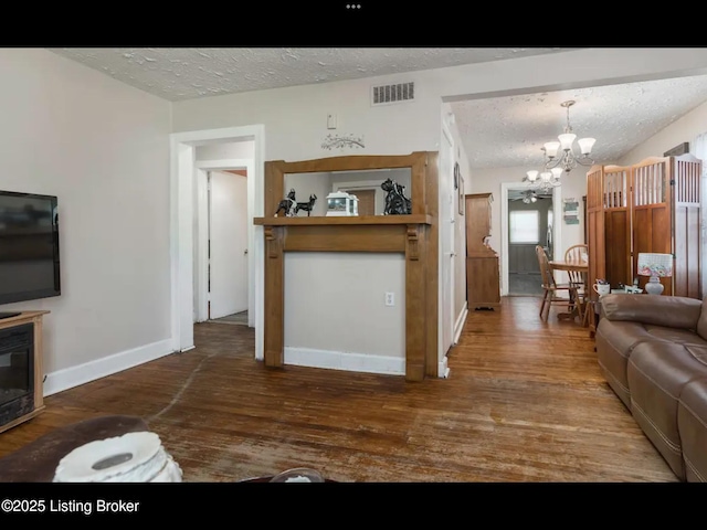 4328 S 1st St, Louisville, KY 40214 - living area with a textured ceiling, a glass covered fireplace, a chandelier, wood finished floors, and baseboards