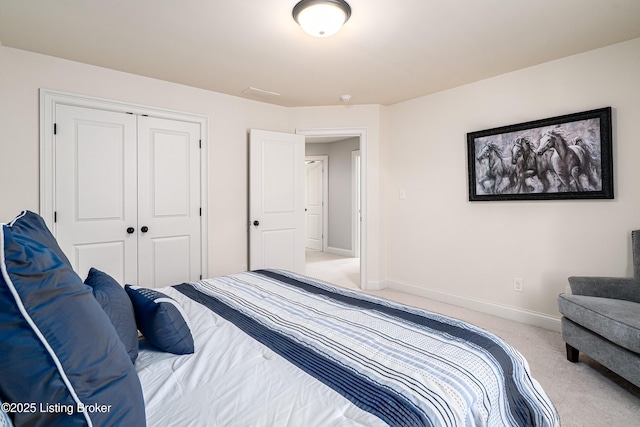 carpeted bedroom featuring a closet and baseboards