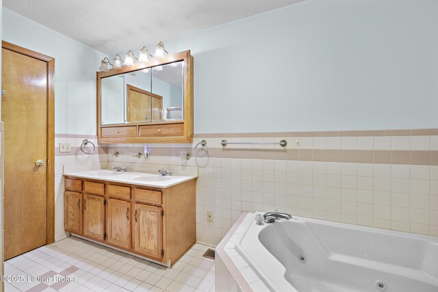 7601 Greenfield Ave, Louisville, KY 40214 - bathroom with a tub with jets, tile walls, tile patterned flooring, double vanity, and a wainscoted wall