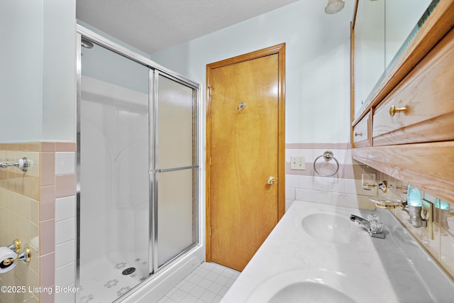 7601 Greenfield Ave, Louisville, KY 40214 - full bathroom with a stall shower, tile walls, double vanity, and tile patterned floors