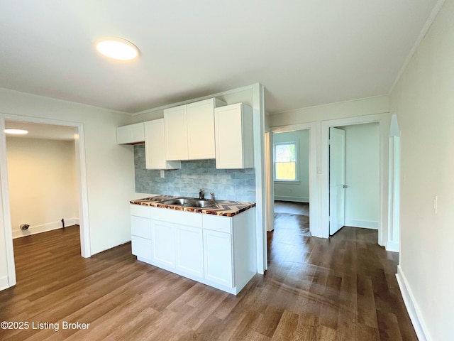 3004 Wayne Rd, Louisville, KY 40216 - kitchen featuring dark wood-style floors, decorative backsplash, white cabinetry, ornamental molding, and dark countertops
