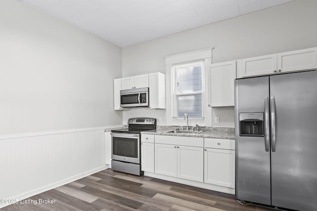 207 Ottawa Ave, Louisville, KY 40214 - kitchen featuring stainless steel appliances, a sink, wainscoting, white cabinetry, and light countertops