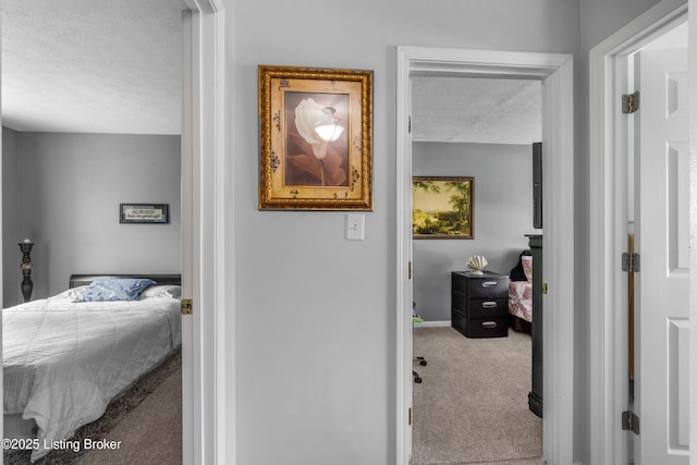 bedroom featuring carpet, a textured ceiling, and baseboards