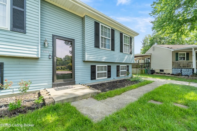 entrance to property featuring central AC and a yard