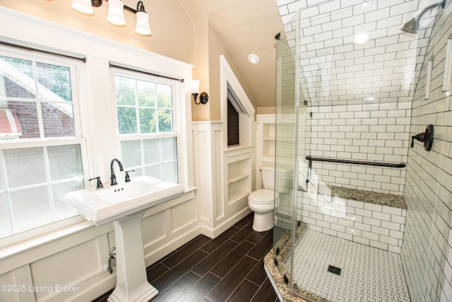 919 Eastern Pkwy, Louisville, KY 40217 - full bath featuring a stall shower, wood finished floors, toilet, and a decorative wall