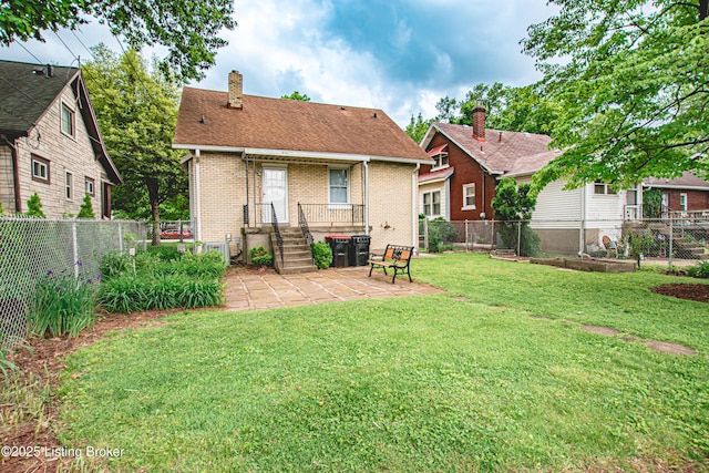 919 Eastern Pkwy, Louisville, KY 40217 - back of house featuring a chimney, brick siding, a patio, and a shingled roof