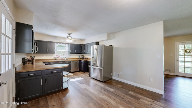 kitchen featuring stainless steel appliances, dark wood-type flooring, and plenty of natural light