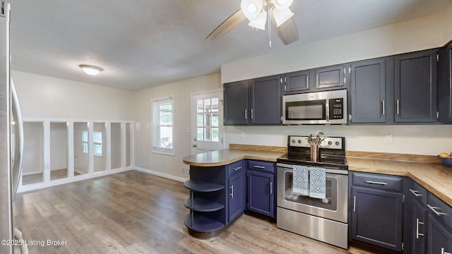 kitchen with appliances with stainless steel finishes, light wood finished floors, ceiling fan, and open shelves