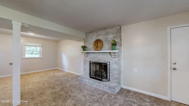 unfurnished living room with carpet floors, a brick fireplace, a textured ceiling, and baseboards