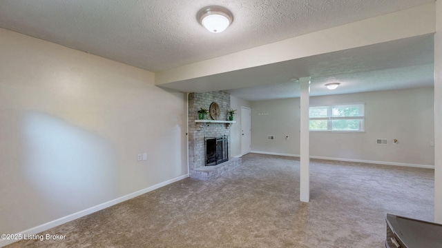 unfurnished living room with a fireplace, a textured ceiling, carpet flooring, and baseboards
