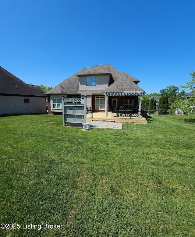 rear view of house with a patio, a lawn, and stucco siding