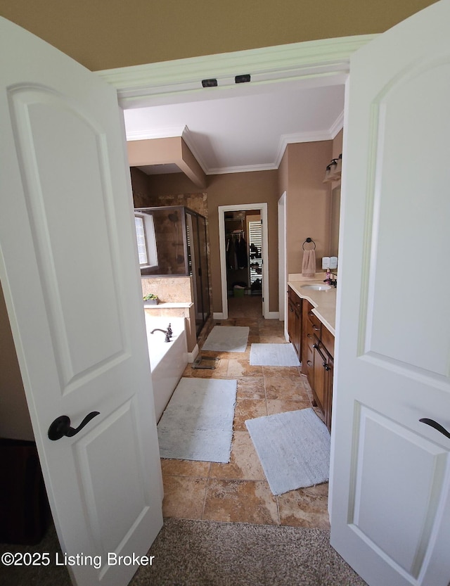 full bath featuring a shower stall, ornamental molding, stone tile flooring, vanity, and a bath