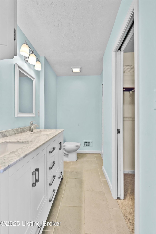 7208 Iron Gate Ct, Louisville, KY 40241 - full bath featuring a textured ceiling, toilet, vanity, a spacious closet, and baseboards