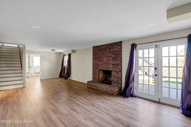 7208 Iron Gate Ct, Louisville, KY 40241 - unfurnished living room featuring healthy amount of natural light, wood finished floors, stairway, and a brick fireplace