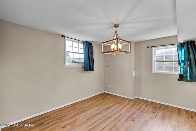 7208 Iron Gate Ct, Louisville, KY 40241 - spare room with baseboards, wood finished floors, a chandelier, and healthy amount of natural light