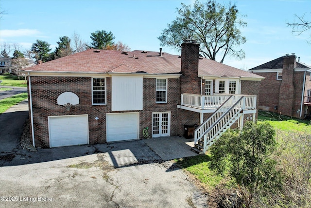 7208 Iron Gate Ct, Louisville, KY 40241 - rear view of house with a chimney, a wooden deck, brick siding, a garage, and stairway