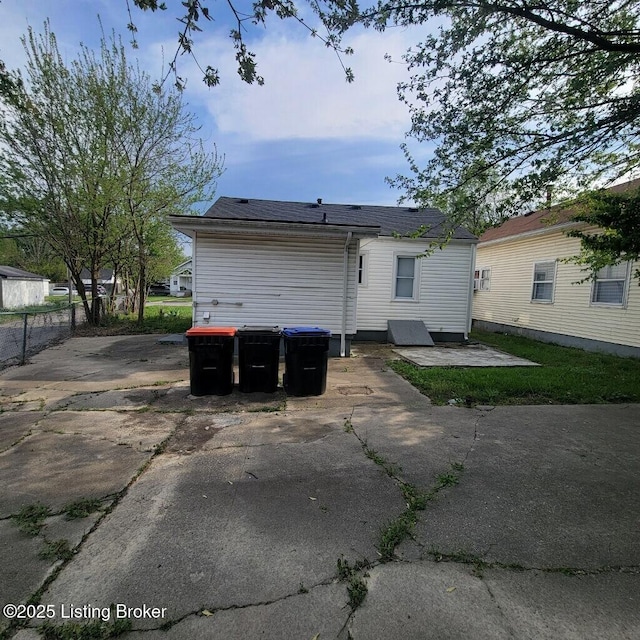 rear view of property featuring a patio and fence