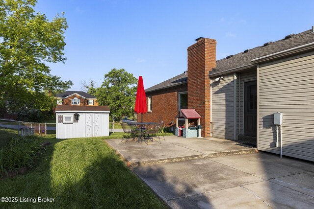 12100 Edenwood Dr, Louisville, KY 40243 - rear view of property featuring a patio, a storage shed, an outbuilding, a chimney, and roof with shingles