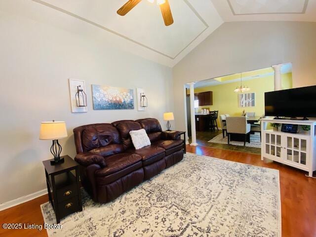 living area with ceiling fan, wood finished floors, baseboards, and high vaulted ceiling
