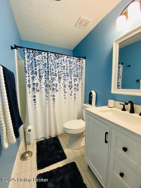 full bathroom featuring a textured ceiling, toilet, vanity, and a shower with shower curtain