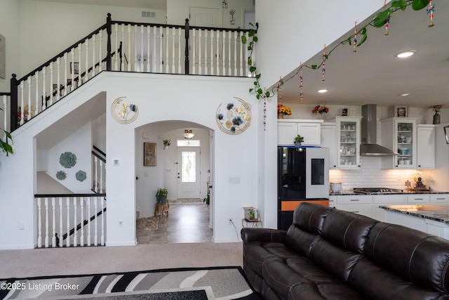 15803 Stonehouse Ct, Louisville, KY 40245 - living room featuring arched walkways, a towering ceiling, stairs, carpet floors, and recessed lighting