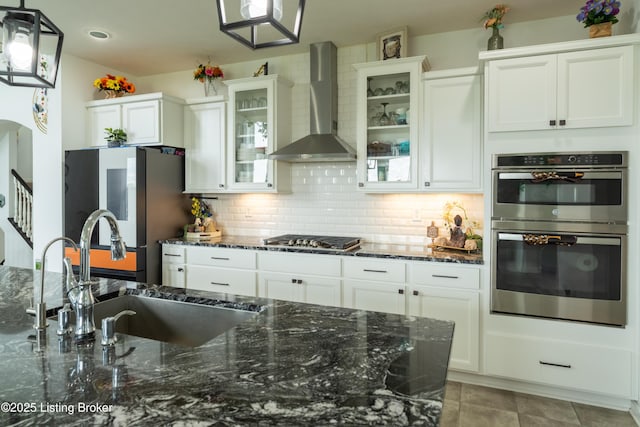 15803 Stonehouse Ct, Louisville, KY 40245 - kitchen with wall chimney exhaust hood, appliances with stainless steel finishes, decorative backsplash, and white cabinetry