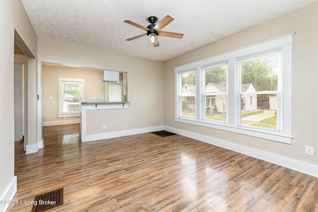 835 Sylvia St, Louisville, KY 40217 - unfurnished living room with ceiling fan, baseboards, wood finished floors, and a textured ceiling