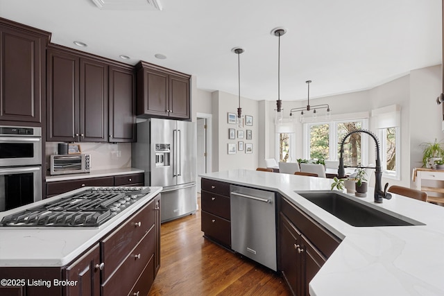 7006 Breakwater Pl, Prospect, KY 40059 - kitchen with stainless steel appliances, a sink, dark brown cabinets, light stone counters, and recessed lighting