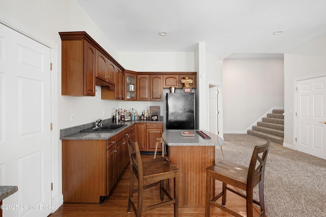 7006 Breakwater Pl, Prospect, KY 40059 - kitchen featuring freestanding refrigerator, a sink, a center island, a kitchen breakfast bar, and glass insert cabinets
