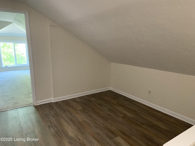 2532 Garland Ave, Louisville, KY 40211 - additional living space featuring lofted ceiling, dark wood-style floors, baseboards, and a textured ceiling