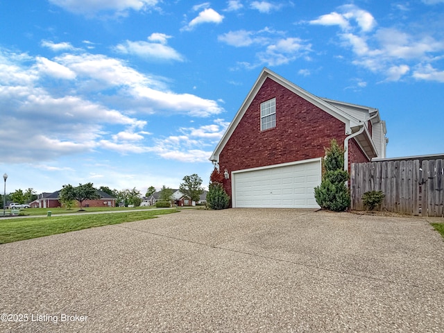 view of home's exterior featuring driveway, brick siding, fence, and a garage