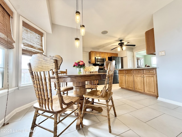 dining space with baseboards, light tile patterned floors, and a ceiling fan