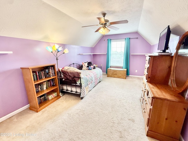carpeted bedroom featuring a textured ceiling, vaulted ceiling, baseboards, and a ceiling fan