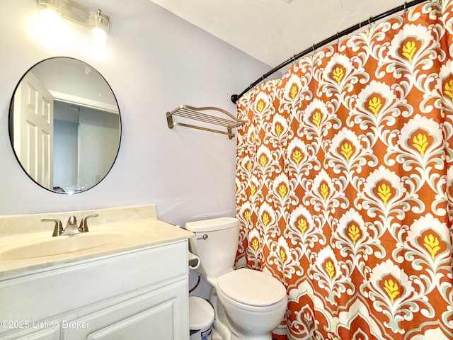 bathroom featuring toilet, vanity, and curtained shower