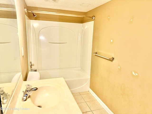 full bath with a sink, tile patterned floors,  shower combination, baseboards, and toilet