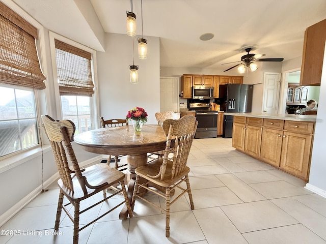 dining space with light tile patterned floors, baseboards, and a ceiling fan