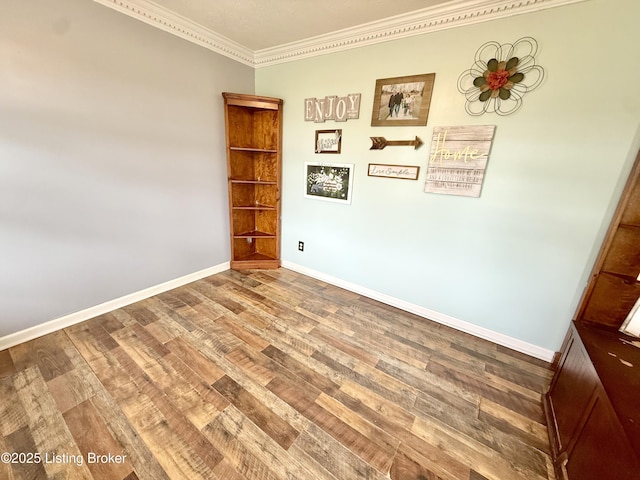 unfurnished room featuring ornamental molding, wood finished floors, and baseboards