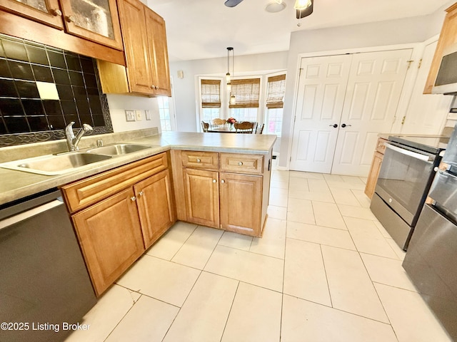 kitchen with stainless steel appliances, a sink, a peninsula, ceiling fan, and glass insert cabinets