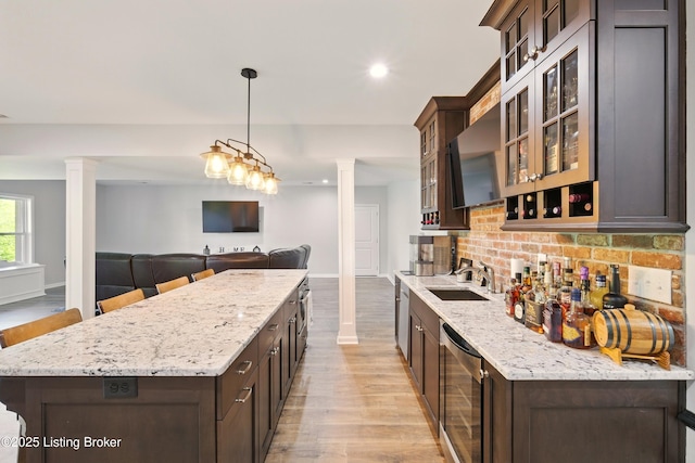3403 Heather Wood Dr, La Grange, KY 40031 - kitchen with decorative columns, a sink, beverage cooler, dark brown cabinetry, and recessed lighting