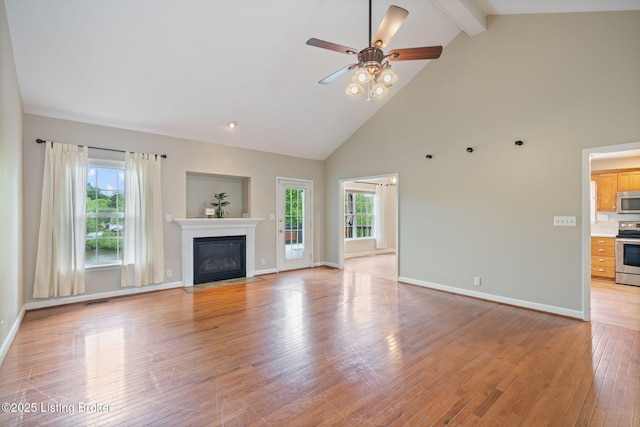 1613 E Crystal Dr, La Grange, KY 40031 - unfurnished living room featuring high vaulted ceiling, beam ceiling, a fireplace with flush hearth, light wood-type flooring, and ceiling fan