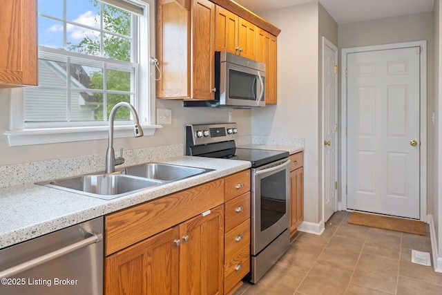 1613 E Crystal Dr, La Grange, KY 40031 - kitchen with appliances with stainless steel finishes, a sink, light countertops, light tile patterned flooring, and brown cabinets